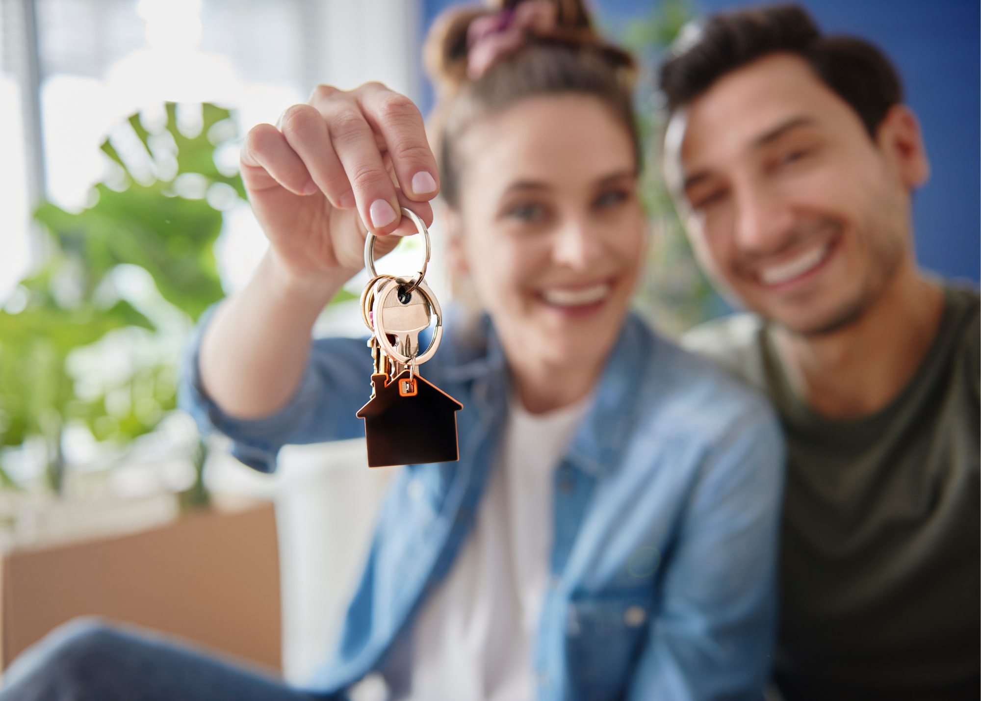 Young couple smiling holding keys to first home