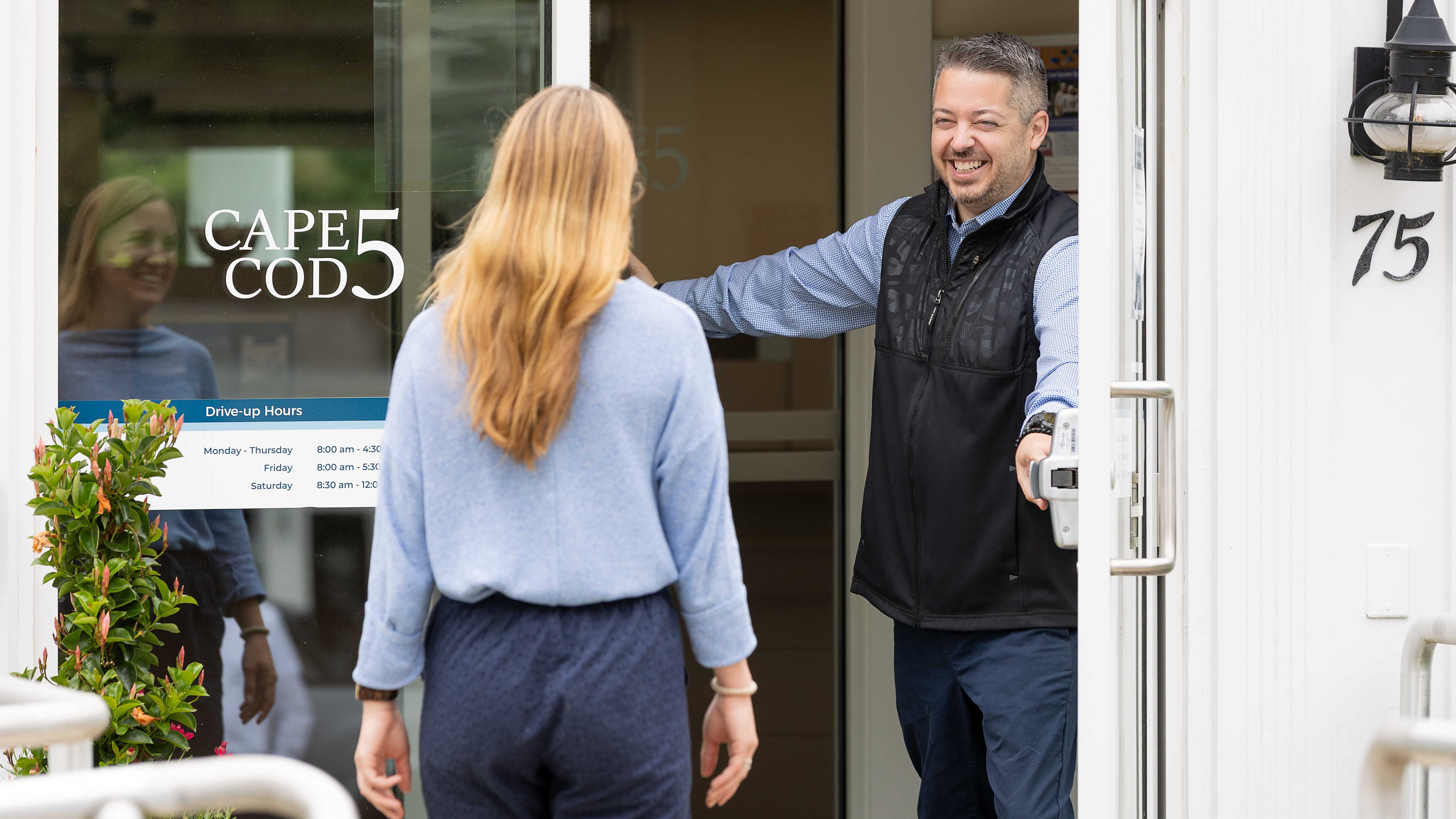 Banking Center employee holding door open for customer