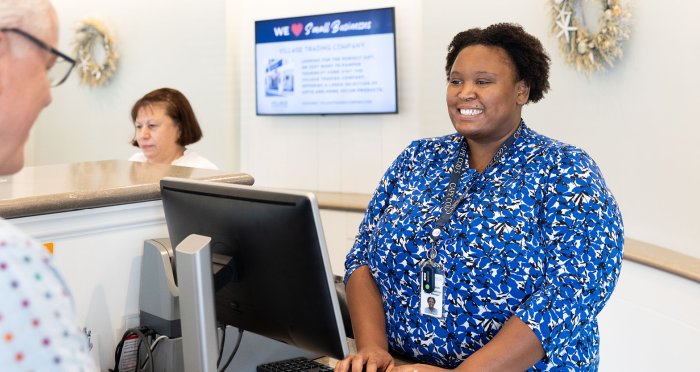 Woman at teller line on computer helping customer