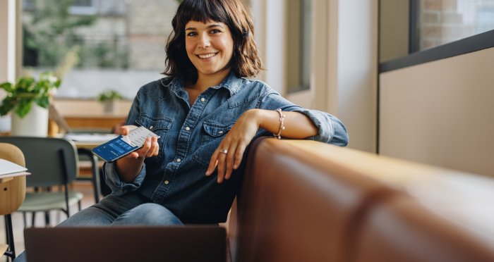 Woman on couch banking on cell phone
