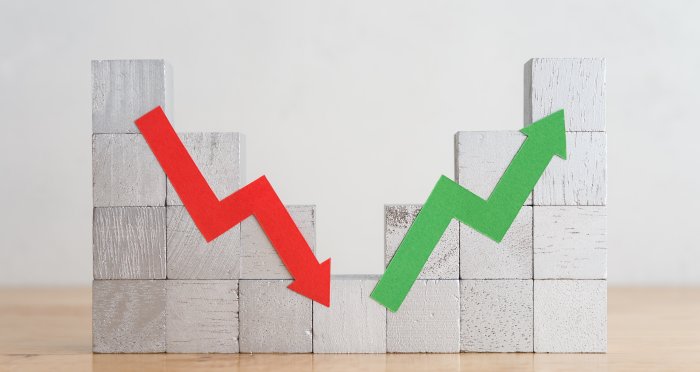 Wood bar chart and arrow red green graph chart volatility up and down on wooden table white wall background. Business, financial and investment concept. 
