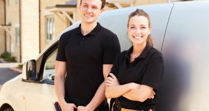 Man and women leaning against white work van