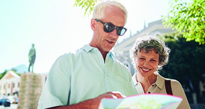 Smiling retired couple looking at map