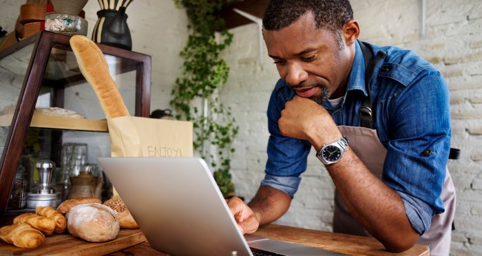 Businessman using computer on counter at bakery