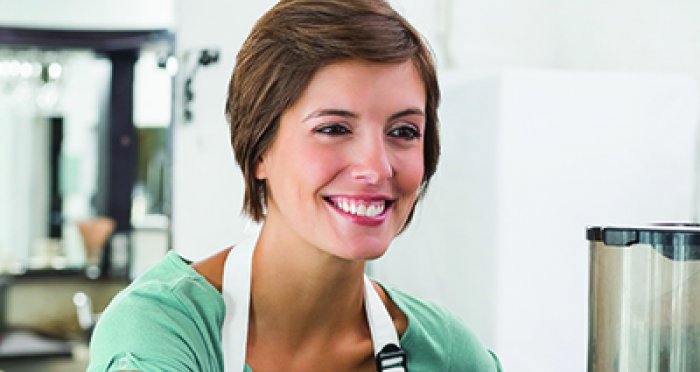 Smiling barista serving a beverage to a customer