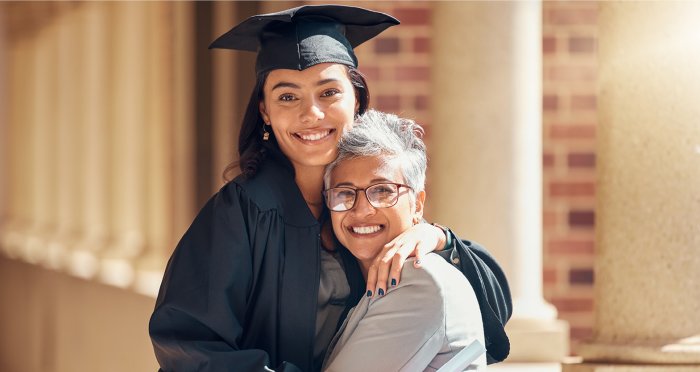 Mother hugging daughter at graduation ceremony