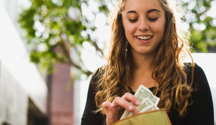 Teenage girl pulling money from wallet