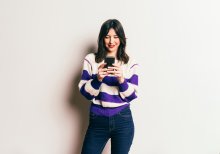 Millennial woman looking at mobile phone and smiling 